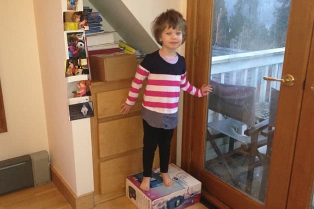 Young child standing on box with no socks on