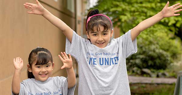 Two girls with Live United T-shirts