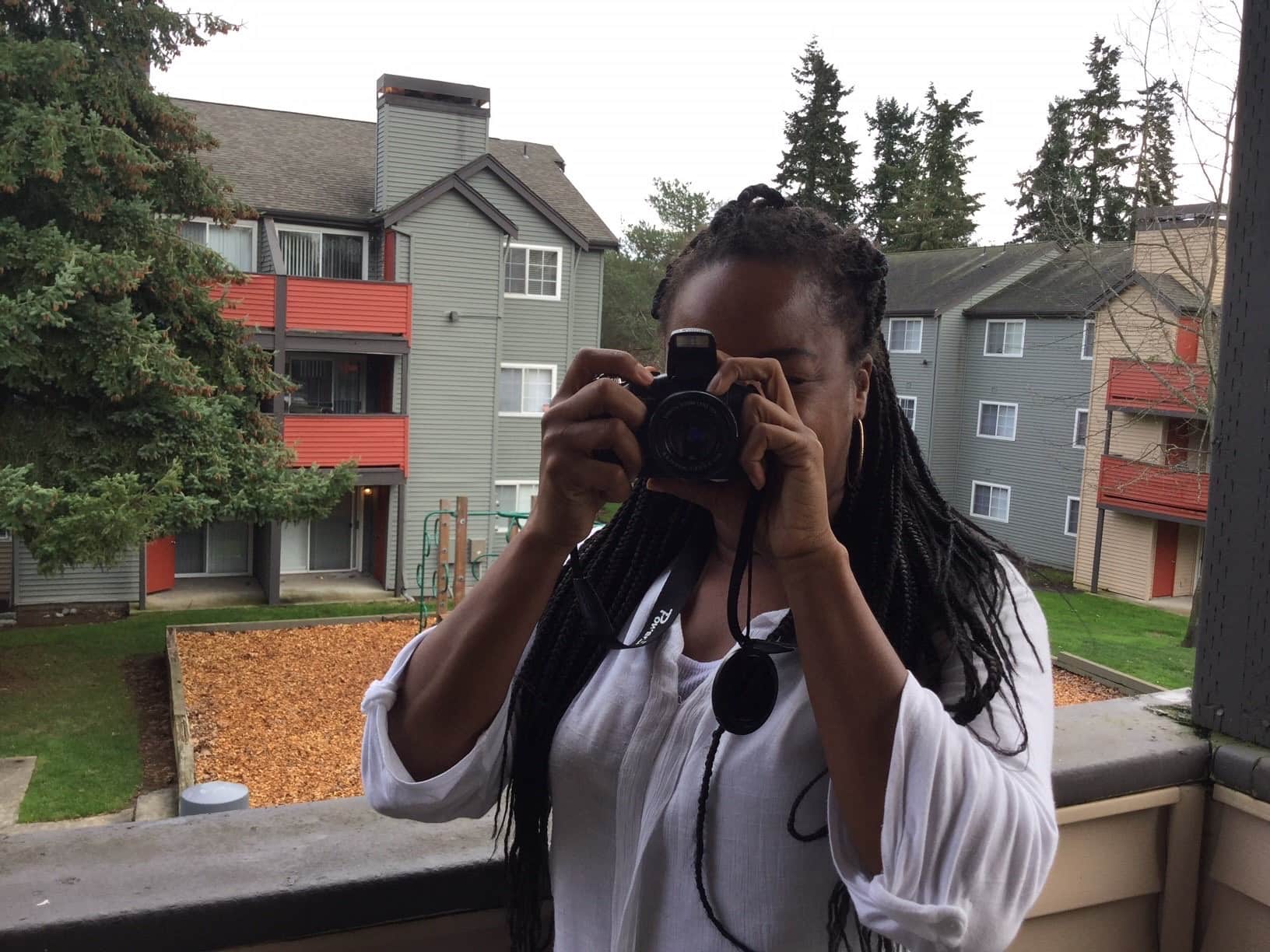 Photo of Nikita with her camera after moving out of homelessness into an apartment