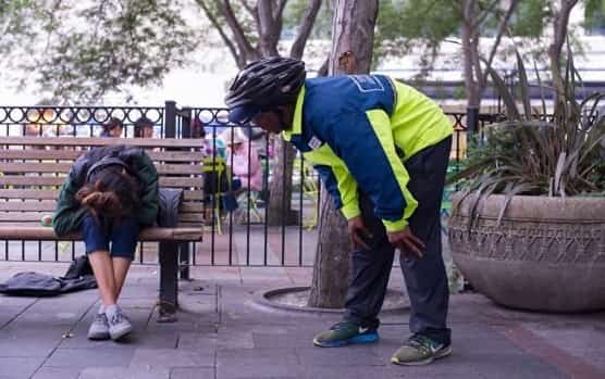 Street safety team member Justin checks on woman on city bench as part of his work with United Way Jobs Connect and Seattle Metropolitan Improvement District