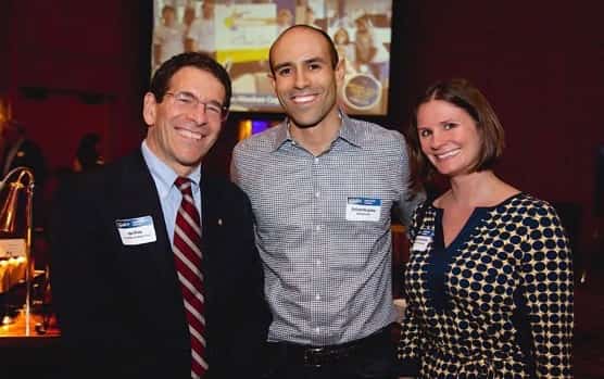 United Way CEO Jon Fine smiling with two younger donors at the United Way breakfast event