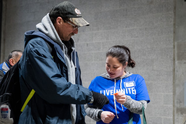 Street safety team member Justin checks on woman on city bench as part of his work with United Way Jobs Connect and Seattle Metropolitan Improvement District