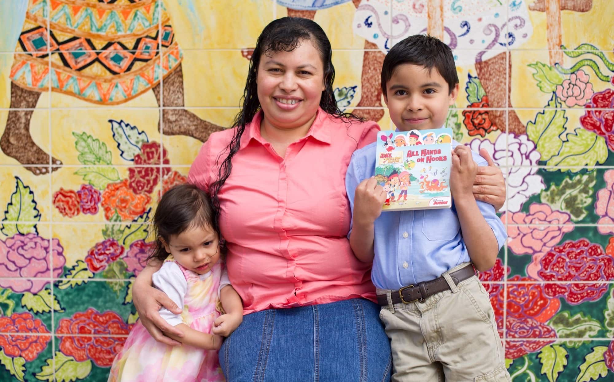 Mom with toddler son and daughter, son holds certificate from Parent-Child Home Program, which gets kids ready for kindergarten and success throughout school.