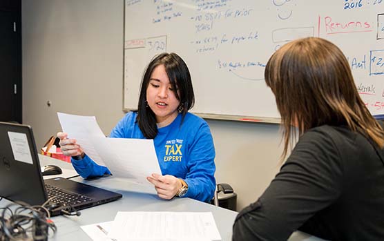 female volunteer helps client with tax preparation for free with United Way