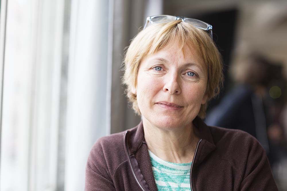 Photo of a woman looking at the camera and smilling.