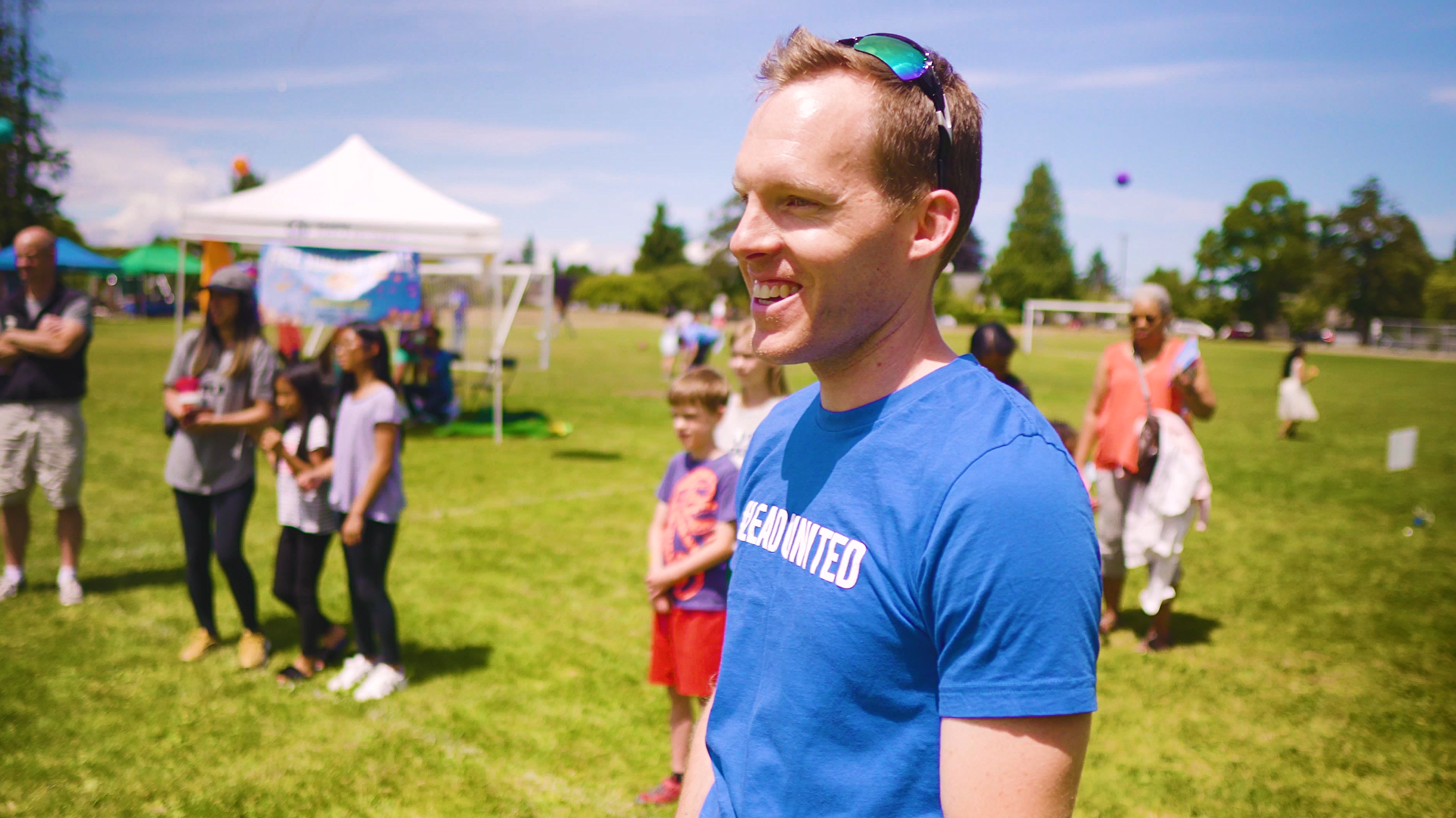 A profile image of the blog's author, a white male in his 30s with blond hair, smiling at something off camera. He wears a shirt that says LeadUnited. behind him are people watching kids playing various outdoor games. It is a sunny day.