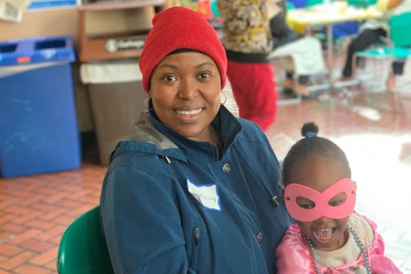 A mother and her three children pose for a photo at the Family Resource Exchange