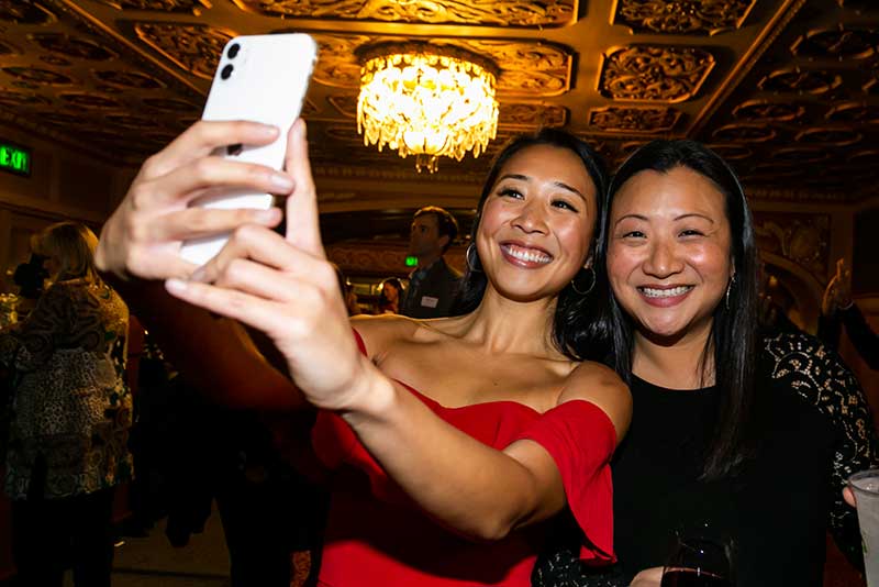To women stand together and pose for a selfie at Eat, Drink and Be Generous event 2019