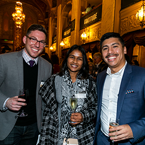 Three people stand and smile while holding wine glasses at the Eat, Drink and Be Generous 2019 fundraising event