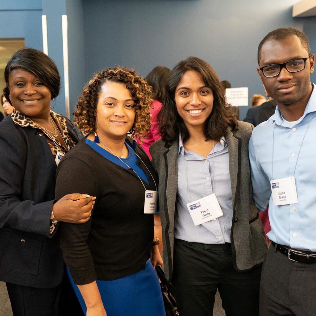 Group of four Project LEAD graduates stand together and pose for a picture