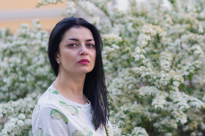 A pensive woman in a garden.