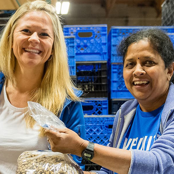 Two people volunteering at a food pantry.