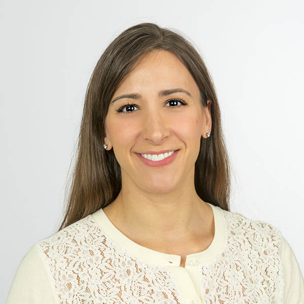 Professional headshot of Melanie. She is smiling at the camera wearing a cream color blouse.