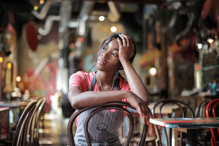 A restaurant worker sitting alone in an empty restaurant