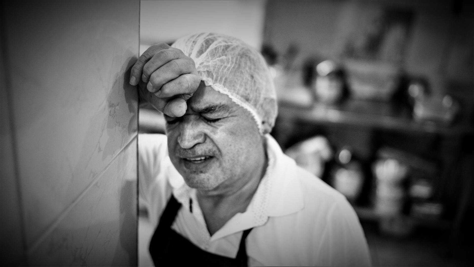 A kitchen worker looking tired and worried.