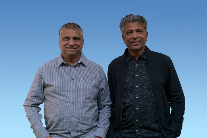 Two men standing next to each other smiling.