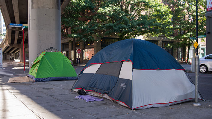 Two tents of people experiencing homelessness on the sidewalk in downtown Seattle.