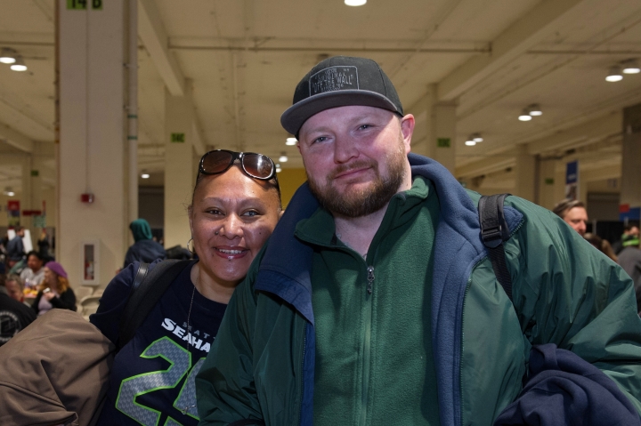 A man and a woman in a room smiling and looking at the camera.