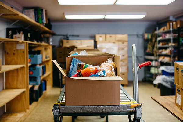 storage room with a conveyor belt containing several boxes with groceries