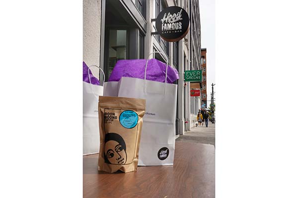 A bag of Boon boona coffee and meal kit sits on a table out front of Hood Famous Bakeshop