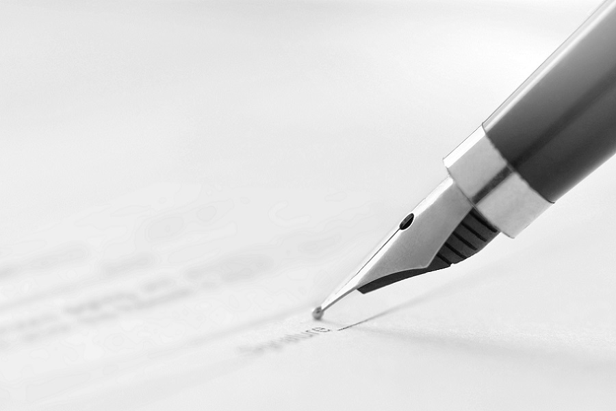 signing a document with an ink pen fountain