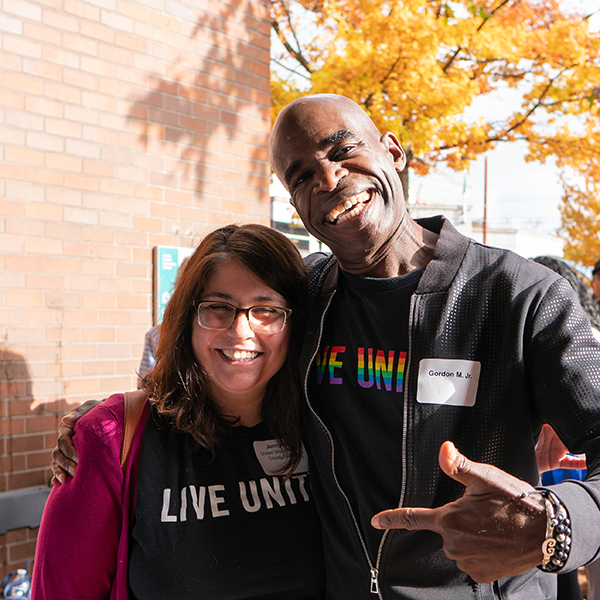 Gordon McHenry, Jr. poses with Jenny with his hand around her shoulder they are both wearing Live United shirts