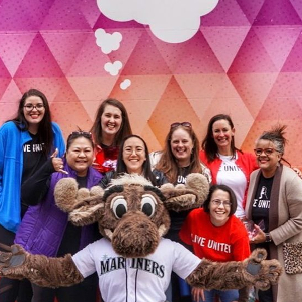 Staff group photo infront of Seattle Heart sticker outside of United Way building