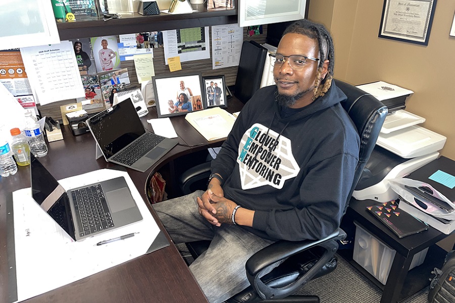 Image of Kendrick Glover, founder of Glover Empower Mentoring, seated in front of a desk in his Kent Office