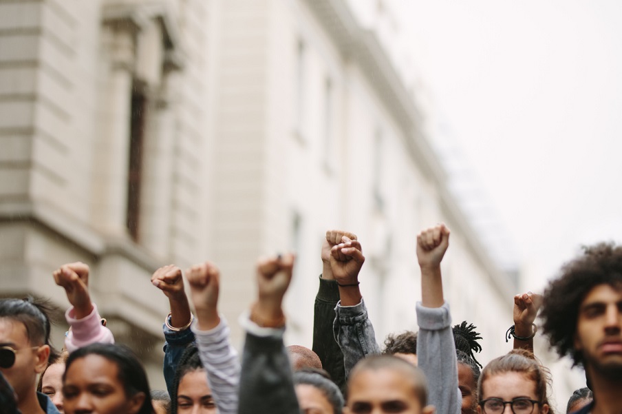 Arms raised in protest. Group of protestors fists raised up in the air.