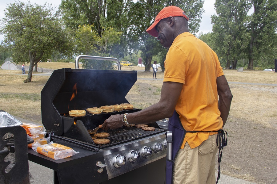 United Way of King County President and CEO Gordon McHenry, Jr. cooking food on a barbecue grill