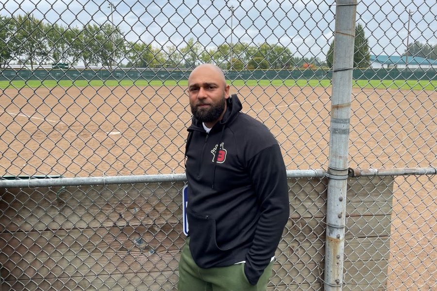 Baseball Beyond Borders founder Bookie Gates outside a gated baseball field