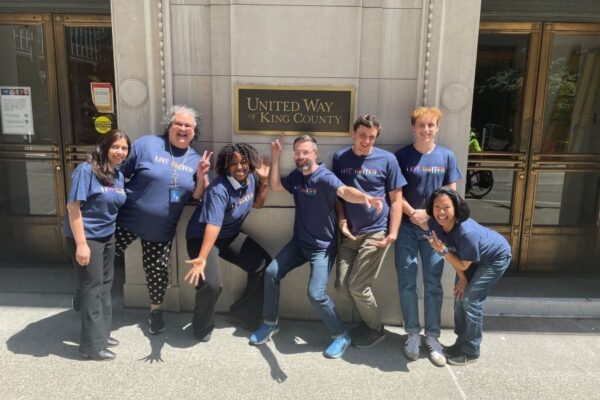 United Way of King County employees marching in the 2019 Seattle Pride parade. The people in the front are caring a large rainbow colored banner that says 