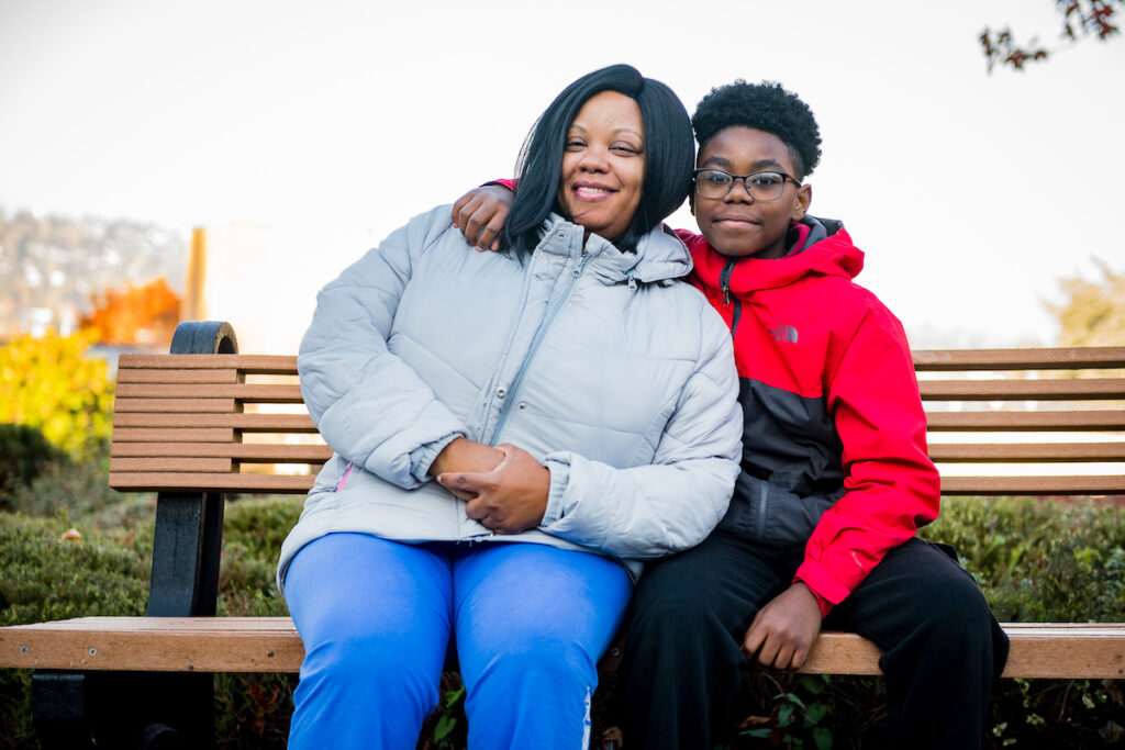 Mother sitting on bench with her son smiling