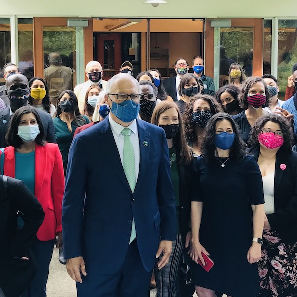 Jay Inslee standing with group in masks